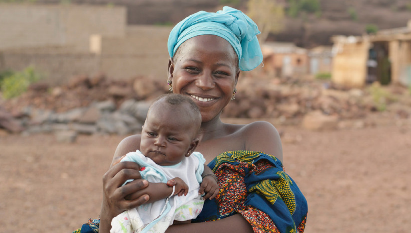 Mother in Africa holding her baby and smiling at the camera